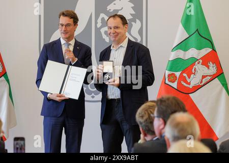 23.08.2024. Düsseldorf. NRW-Ministerpräsident Hendrik Wüst (li.) verleiht den Verdienstorden des Landes Nordrhein-Westfalen an Jacques Tilly (re.). Stockfoto