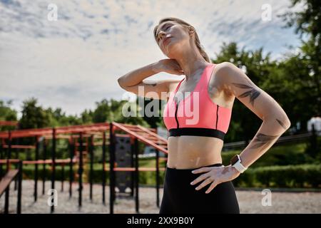 Eine junge Frau mit Vitiligo streckt ihren Hals nach dem Training im Freien. Stockfoto