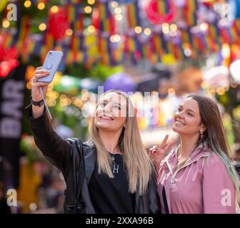 (l-r) die Mancunianer Devon und Lucy posieren für ein Selfie auf der Canal Street im Manchesters Gay Viertel, als Sturm Lilian den Beginn von Manchester Stolz für die frühen Ankünfte nicht behindert. Manchester Pride 2024 . Das diesjährige Thema lautet „Buzzin to be Queer – A Hive of Progress“, und die Organisatoren hoffen, dass es „die Menschen von Manchester vereinen“ wird, unter dem Symbol der Manchester Bee. Schlagzeilen von Jessie J, Loreen, Sugababes, Rita ora und dem größten Showman-Star Keala Settle. Die erste Pride Parade in Manchester fand am 20. Februar 1988 statt, als im konzil ein massiver Protest gegen die Sektion 28 stattfand Stockfoto