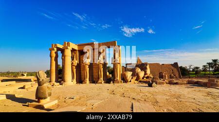 Gefallene Ozymandias, der kolossale Statuenkopf von Ramesses II mit den stehenden Osiris-Statuen im Eingangshof des Ramesseums, Totentempel von Pharoah Ramesses II. Dem Großen in Luxor, Ägypten Stockfoto