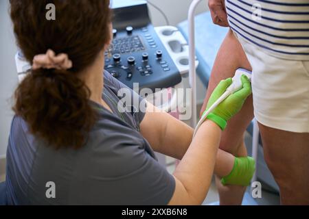 Die Phlebologin führt zu einem Termin eine Ultraschalluntersuchung der Blutgefäße durch Stockfoto