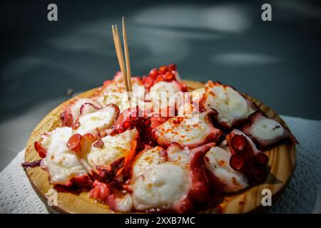 Galicien, Spanien. Gekochter Tintenfisch, der im typisch galizischen Stil zubereitet und auf einem Holzbrett serviert wird. Stockfoto