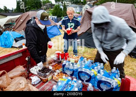 JIM und JOSEY von der Heilsarmee bieten RICK, einem Obdachlosen, das Frühstück an, am letzten Tag im einzigen offiziellen Obdachlosenlager in Everett. Die Stadt o Stockfoto