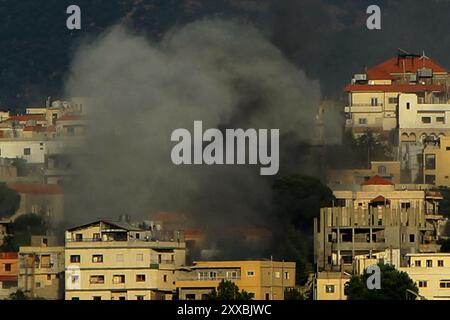 Qliyaa, Qlyiaa, Libanon. August 2024. Zwischen Häusern in der libanesischen südlichen Grenzstadt Khiam weht starker Rauch von einem israelischen Beschuss. Sieben pro-iranische Hisbollah-Kämpfer und ein Kind wurden bei israelischen Angriffen im Südlibanon getötet, als die bewaffnete Gruppe Hisbollah mit Artilleriegeschossen und Raketen über die Grenze reagierte. Das israelische Militär hat parallel zum Gazastreifen-Krieg über die Südgrenze des Libanon hinweg Feuer mit der Hisbollah verhandelt, wobei die Feindseligkeiten in jüngster Zeit angesichts der Befürchtungen, dass ein regionaler Krieg ausbrechen könnte, verstärkt werden. (Kreditbild: © Marwan Naamani/ZUMA Press Stockfoto