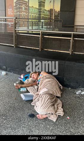 Obdachlose Frau schläft tagsüber vor einer U-Bahn-Station an der 2nd Avenue auf der Upper East Side von New York City. Stockfoto