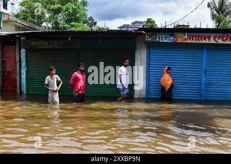 Dhaka, Dhaka, Bangladesch. August 2024. Menschen waten am 23. August 2024 durch Hochwasser im Mohipal, Bezirk Feni in der Division Chittagong, Bangladesch. Mindestens 13 Menschen werden getötet, insgesamt 43 Uupazilas in mehreren Bezirken sind von den Sturzfluten betroffen, und etwa 189.663 Familien werden gedrängt. (Kreditbild: © Zabed Hasnain Chowdhury/ZUMA Press Wire) NUR REDAKTIONELLE VERWENDUNG! Nicht für kommerzielle ZWECKE! Stockfoto