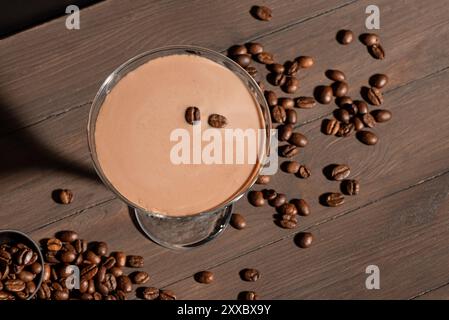 Espresso Martini Cocktail mit Kaffeebohnen auf dunklem Holzhintergrund, Blick von oben. Kaffeelikörgetränk. Stockfoto