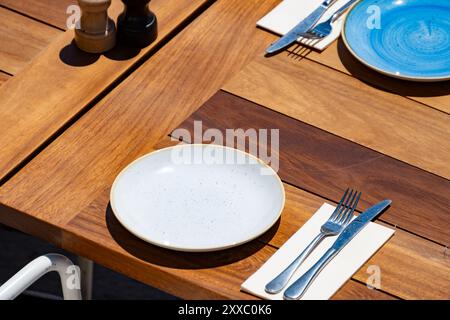Vor dem Mittagessen wartet ein leeres, stilvolles Strandcafé mit Tischen im sonnigen Biarritz, Baskenland, Frankreich Stockfoto