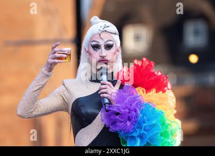 Drag Queen hebt einen Drink auf der Canal Street im Manchesters Gay Quarter ab, als der Sturm Lilian den Start von Manchester Stolz in der ersten Nacht nicht behindert. Manchester Pride 2024 . Das diesjährige Thema lautet „Buzzin to be Queer – A Hive of Progress“, und die Organisatoren hoffen, dass es „die Menschen von Manchester vereinen“ wird, unter dem Symbol der Manchester Bee. Schlagzeilen von Jessie J, Loreen, Sugababes, Rita ora und dem größten Showman-Star Keala Settle. Die erste Pride-Parade in Manchester fand am 20. Februar 1988 statt, als im Stadtzentrum ein massiver Protest gegen die Sektion 28 stattfand. Zu diesem Zeitpunkt war es mit Stockfoto