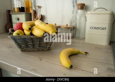 Korb mit frischem Obst auf dem Tisch in der Küche, Bananen auf dem Vorplatz Stockfoto