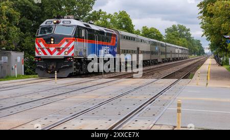 Der BNSF Metra Pendlerzug, der von einer F40PHM-3-Lokomotive geführt wird, fährt zum Bahnhof Riverside, Illinois. Stockfoto