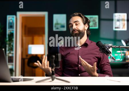 ASMR Creator mit High-Tech-Mikrofon und Smartphone auf Stativ macht Anti-Stress-Videos im gemütlichen Heimstudio. Mann, der professionelles Mikrofon und Telefon verwendet, um entspannende Inhalte für Abonnenten zu erstellen Stockfoto