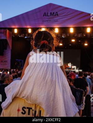 BARCELONA, SPANIEN - 24. Juni 2024: Ein Kind in den Schultern ihres Vaters sieht ein Konzert im Poble Espanyol. Stockfoto