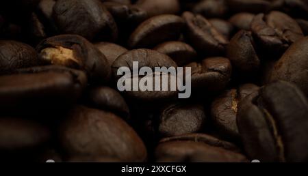 Ein Haufen Kaffeebohnen, die zusammen gestapelt sind und zu einer köstlichen Tasse Kaffee gebrüht werden können. Nahaufnahme gerösteter Arabica-Kaffeebohnen. Verschiedene Typen Stockfoto