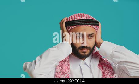 Die Person macht drei kluge Affen im Studio, die traditionelle islamische Kleidung und Kopftuch tragen. Junger Erwachsener, der Augen, Mund und Ohren bedeckt, um Metapher zu erzeugen, Konzept. Stockfoto