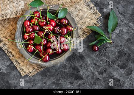 Frische reife Sauerkirschfrüchte in der Schüssel auf rustikalem Tisch, rote Sommerfrüchte Stockfoto