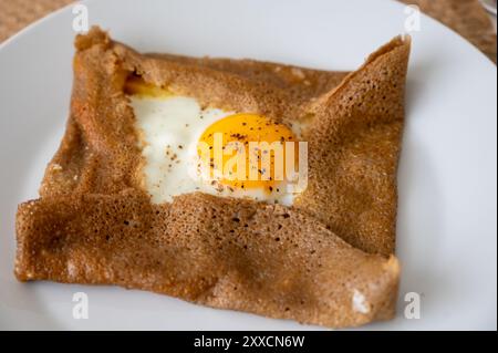 Galettes-Pfannkuchen aus der Bretagne mit Buchweizenmehl, serviert mit herzhaften Toppings, Schmelzkäse und Eiern aus nächster Nähe Stockfoto