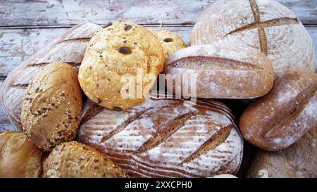 Auswahl an gebackenem Sauerteigbrot auf Holztischbrot. Frisches duftendes Brot auf dem Tisch. Lebensmittelkonzept. Verschiedene Brotsorten. Stockfoto