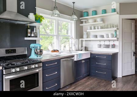 Moderne Landhausküche mit grauen Schränken und großem Waschbecken Stockfoto