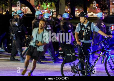 Chicago, Illinois, USA. August 2024. Ein Fotograf läuft nach dem Marsch auf dem DNC-Protest in Chicago um die Polizeiradbarrikade um den Union Park herum (Credit Image: © Chris Riha/ZUMA Press Wire) NUR REDAKTIONELLE VERWENDUNG! Nicht für kommerzielle ZWECKE! Stockfoto