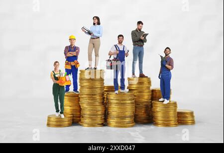 Menschen verschiedener Berufe auf Stapeln von Münzen unterschiedlicher Höhe vor weißem Hintergrund Stockfoto