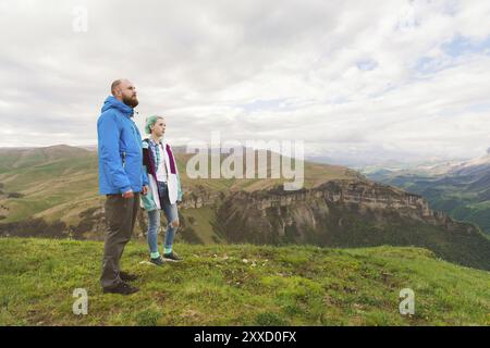 Ein Paar Hipster-Touristen steht nebeneinander in den Bergen vor der Kulisse des Hochplateaus aus Tälern und Himmel. Die Erholung findet man in den mountai Stockfoto