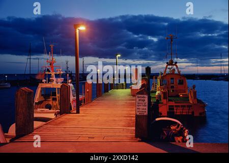 Pilotenboot und kleiner Rettungskreuzer am Abend am Pier im Hafen von Timmendorf, Insel Poel Stockfoto