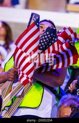 Chicago, Usa. August 2024. Eine Frau trägt Flaggen, die an Delegierte am vierten Tag der Demokratischen Nationalversammlung (DNC) im United Center verteilt werden sollen. Delegierte, Politiker und Anhänger der Demokratischen Partei treffen sich in Chicago, als die derzeitige Vizepräsidentin Kamala Harris zur Präsidentschaftskandidatin ihrer Partei ernannt wird. Die DNC findet vom 19. Bis 22. August statt. Quelle: SOPA Images Limited/Alamy Live News Stockfoto