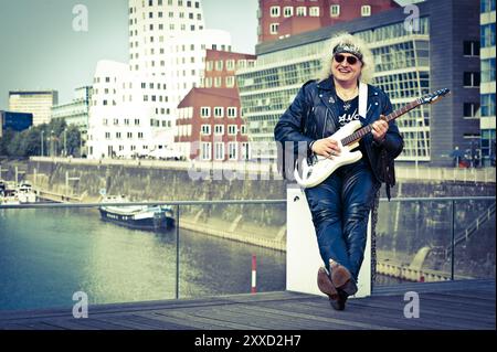 Rockmusiker mit Gitarre im Düsseldorfer Medienhafen Stockfoto