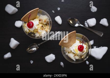 Durian-Eis mit Kirschen und Waffel auf schwarzem Holz Hintergrund Stockfoto