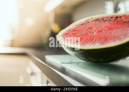 Eine frisch geschnittene Melonenhälfte liegt auf der Arbeitsplatte in der Küche Stockfoto