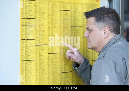 Ein Mann steht vor einem Zeitplan Stockfoto