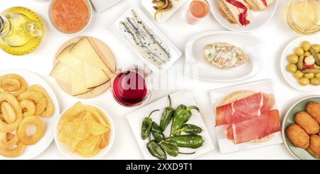 Ein Panorama der spanischen Tapas und Wein, ein Foto, eine Auswahl an Snacks. Manchego Käse, jamon, padron Paprika, Sardinen, Tintenfischringe, Oliven Stockfoto