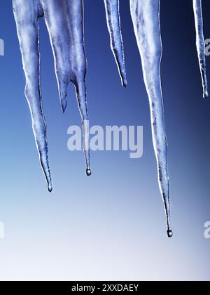 Schmelzende Eiszapfen auf blauem Hintergrund isoliert Stockfoto