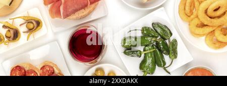 Spanische Tapas und Wein, ein Panoramablick über der Decke mit einer Vielzahl von Snacks. Padron-Paprika, Marmelade, Chorizo, Tintenfische, gildas, Schuss von oben auf einem W Stockfoto