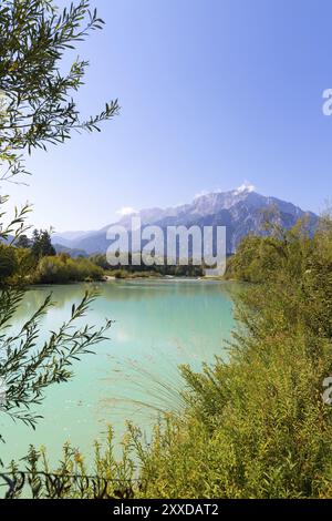 Idyllischen ufer Landschaft: Kristallklares Wasser, Blumen, Pebble Beach und Berge Stockfoto