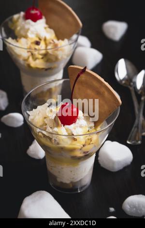 Durian-Eis mit Kirschen und Waffel auf schwarzem Holz Hintergrund Stockfoto