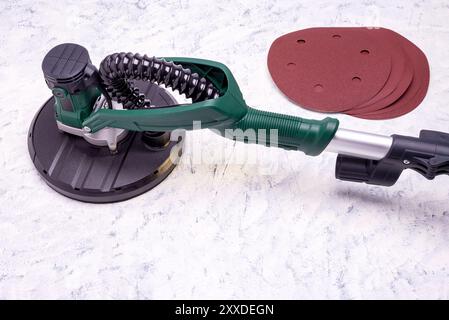 Wandschleifer mit Teleskopgriff und LED-Licht und Schleifpapier zum Glätten und Schleifen von Wänden auf grauweißem Hintergrund mit Kopierraum für Text. Stockfoto