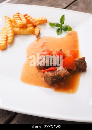 Lecker organische Gulasch mit Pommes frites auf einer weißen Platte Stockfoto