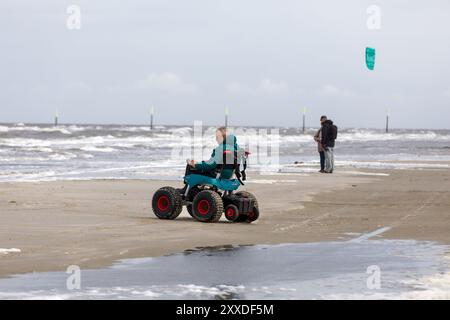 Mann mit Handicap am Strand mit Strandrollstuhl, Sankt-Peter-Ording, Schleswig-Holstein Stockfoto