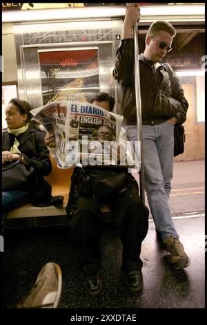 Mann in der U-Bahn, der die spanische New Yorker Zeitung "El Diario" liest, mit der Überschrift "nur Englisch" auf der Titelseite. Stockfoto