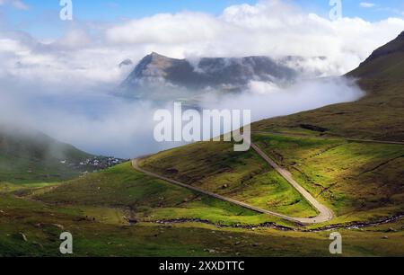 Bergstraße über Nebel im Funningur Fjord auf Eysturoy Island, Färöer Inseln. Stockfoto