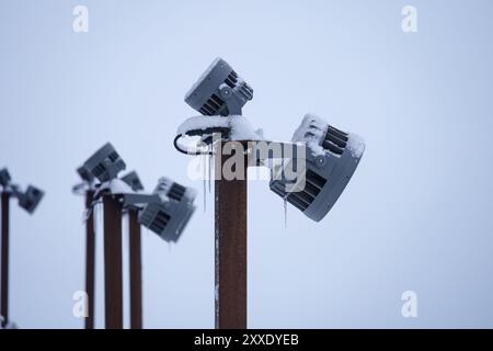 Schneebedeckte Leuchten an Stangen im Winter, Nahaufnahme Stockfoto