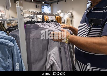 Mann, der Kleidung im Einkaufszentrum auswählt Stockfoto