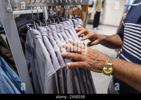 Mann, der Kleidung im Einkaufszentrum auswählt Stockfoto