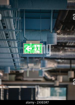 Notausstiegsschild. Büroflächen. Industriedecke Stockfoto