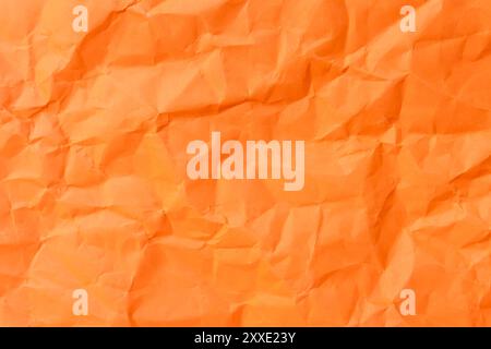Die Draufsicht und der ganze Rahmen von zerknittertem oder zerknittertem orangefarbenem Papier werden als Hintergrund für zerknittertes orangefarbenes Papier verwendet. Stockfoto