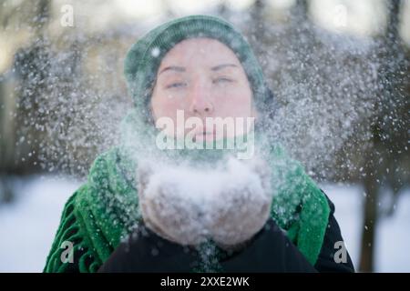 Jugendlich Mädchen bläst frischen Schnee in kalten Wintertag, flacher Fokus Stockfoto