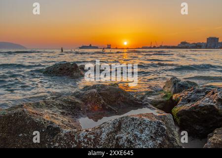 Sonnenuntergang am Strand in der Nähe der Stadt Vlorë in Albanien, die sich an der Bucht von Vlorë ausbreitet und von den Ausläufern der Ceraunischen Berge Ao umgeben ist Stockfoto