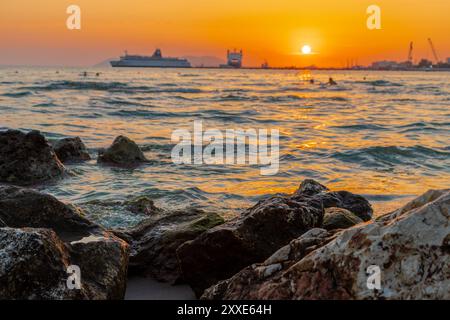 Sonnenuntergang am Strand in der Nähe der Stadt Vlorë in Albanien, die sich an der Bucht von Vlorë ausbreitet und von den Ausläufern der Ceraunischen Berge Ao umgeben ist Stockfoto